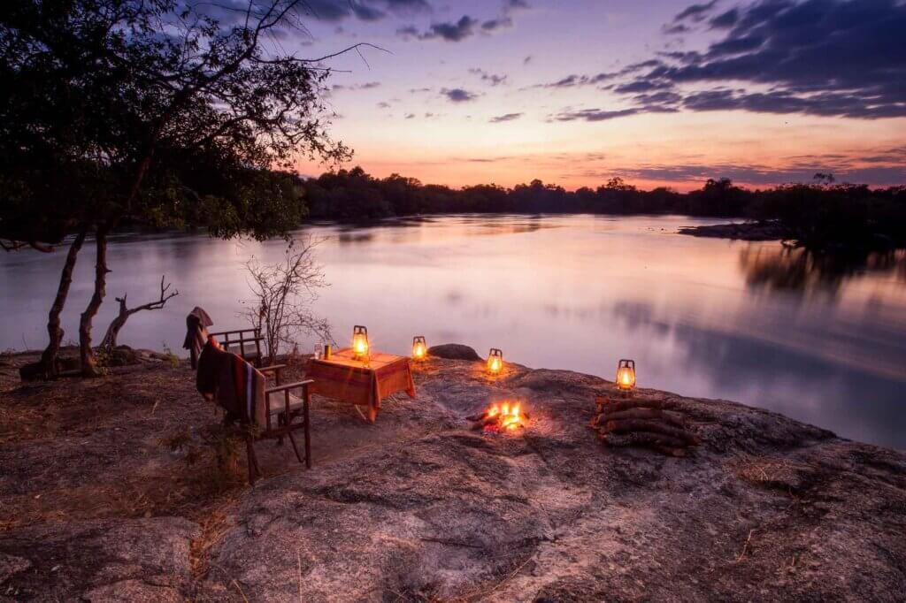 Stimmungsvolle Abendstimmung mit Blick auf den Kafue River in Sambia. Wir warten aufs Abendessen und freuen uns auf die zauberhafte Nacht im Busch.