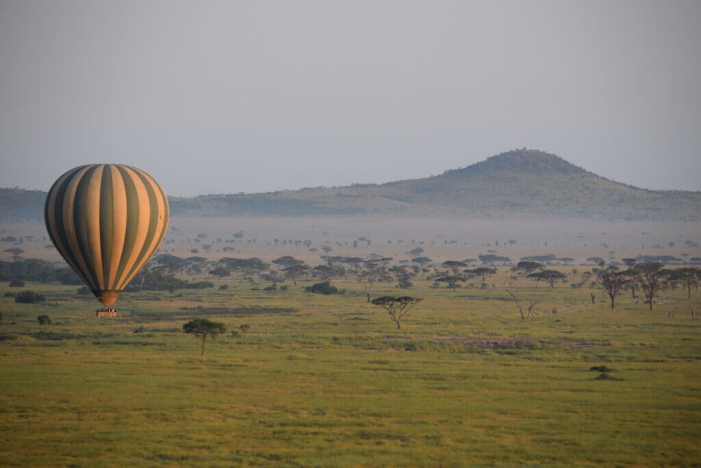 Ein Ballon schwebt über die Weiten der Serengeti. Die Ballonfahrt ist für viele Besucher der Höhepunkt einer Safari in der Serengeti. 