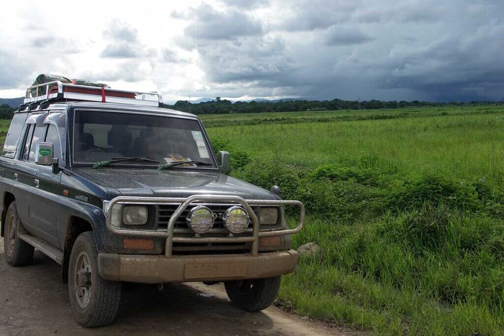 Ein grüner Toyota Prado posiert vor einem Reisfeld in Kyela, Südtansania