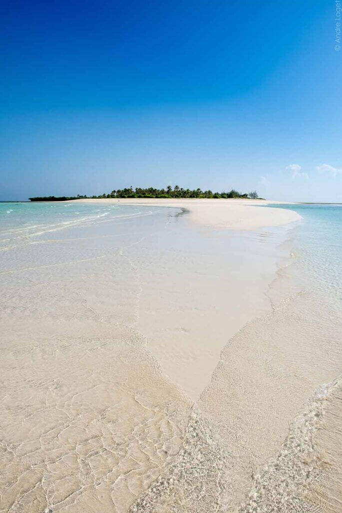 Sanfte Wellen umspülen eine langgezogene Sandbank vor dem kleinen Eiland Fanjove Island, eine vorgelagerte Insel vor der Küste von Tansania. Das türkisblaue Meer leuchtet verführerisch!